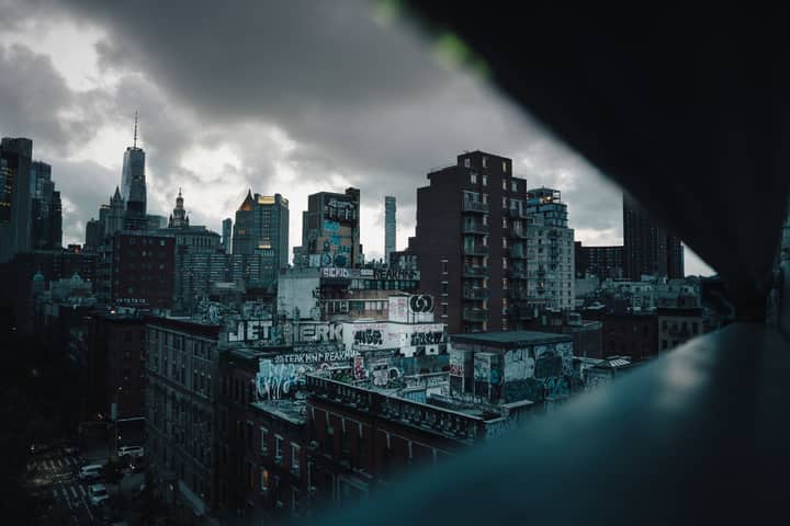 Moody view of New York City's skyline with dramatic clouds and urban graffiti.