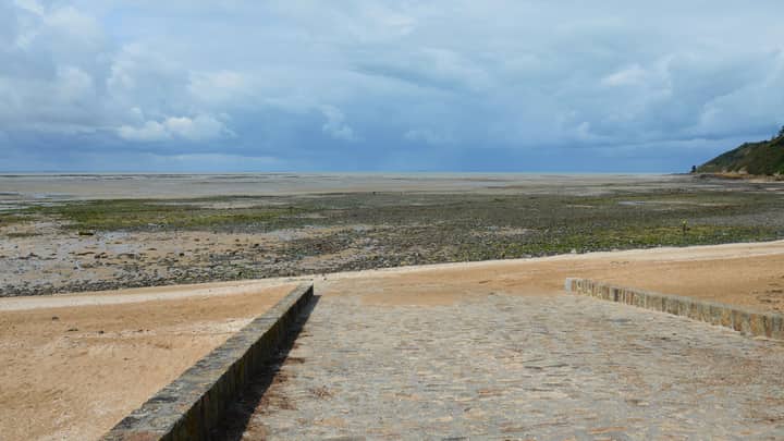 Tranquil view of the beach during low tide at Saint-Jean-le-Thomas, Normandie, France.