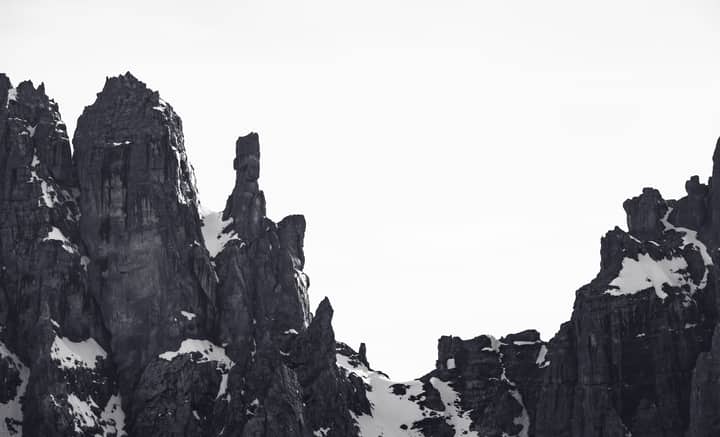 Black and white view of rocky snow-covered peaks in Madonna di Campiglio, Italy.
