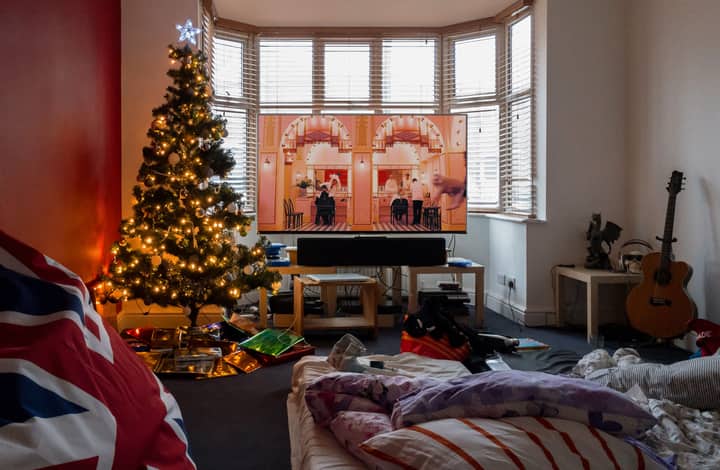 Warm and inviting Christmas living room with a lit tree, holiday decor, and a cozy atmosphere.