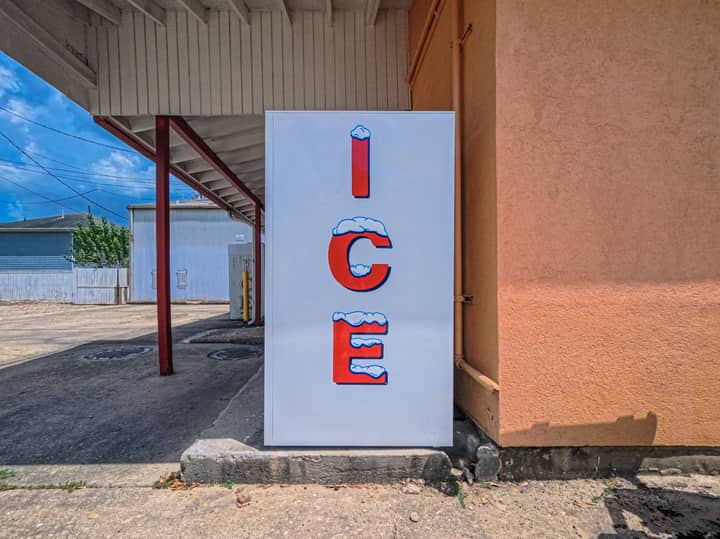 Outdoor ice machine with bright signage in Houston, TX on a sunny day.