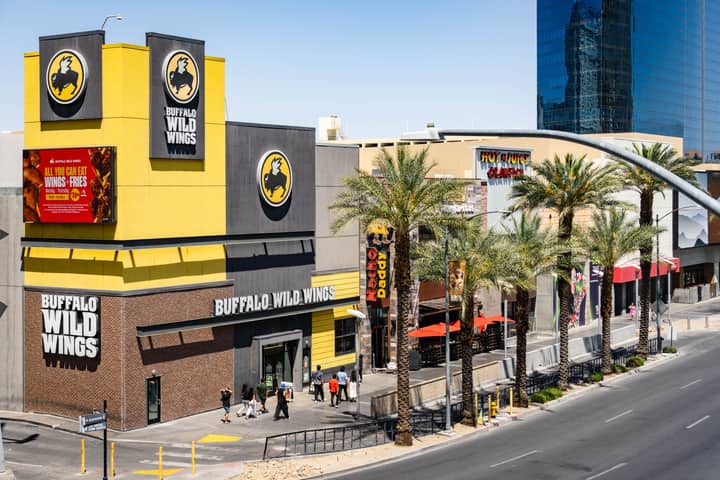 Buffalo Wild Wings located on the bustling Las Vegas Strip with palm trees and pedestrians.