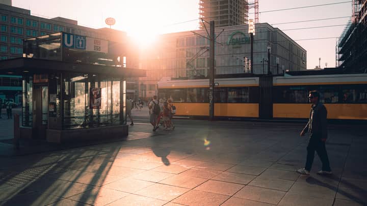 Vibrant sunset at Alexanderplatz, Berlin showcasing urban life and architecture.