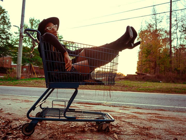 Fashionable woman lounging in a shopping cart on a sunny day in Atlanta, Georgia.
