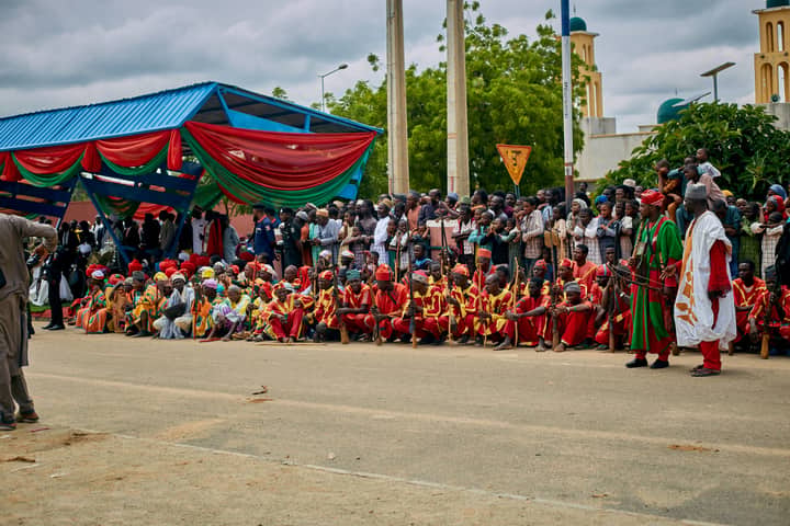 Vibrant street parade with traditional attire and crowd in Nigeria.
