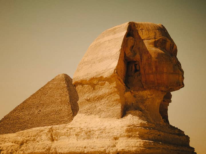 Majestic view of the Great Sphinx and Pyramid in Egypt, showcasing ancient architecture.