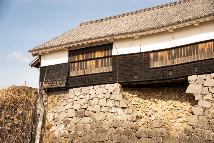 Aged stone wall of Kumamoto Castle with its iconic traditional architecture, Japan.