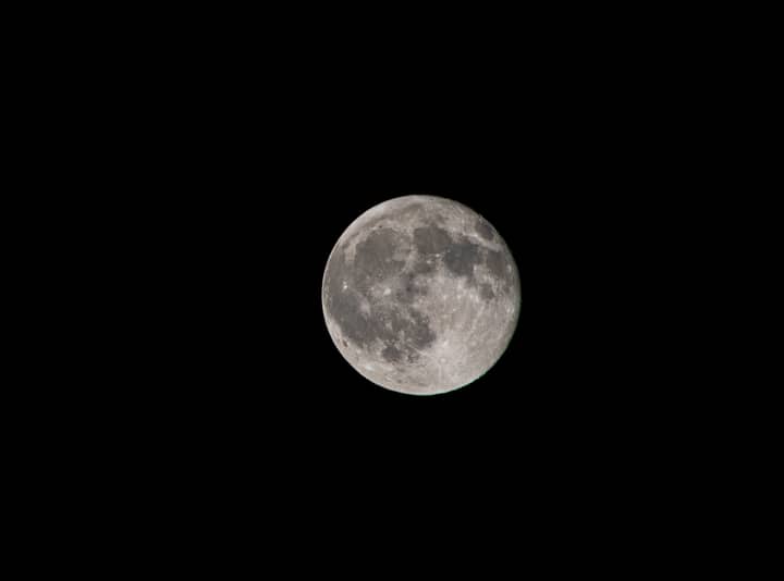 A high-resolution image of the full moon against a black night sky, showcasing lunar details.