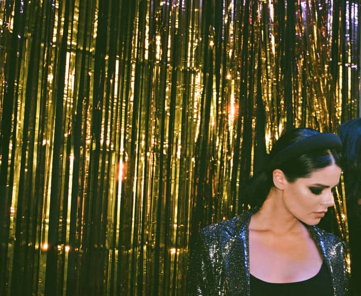 A stylish woman in sparkling attire at a glamorous New Year's Eve celebration.