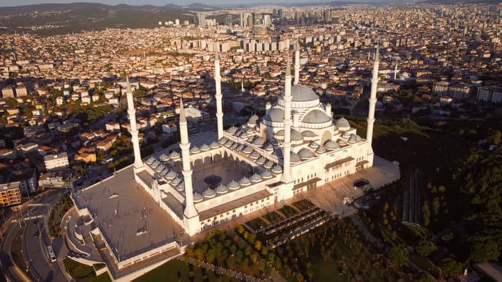 Stunning aerial view of Çamlıca Mosque in Istanbul during sunset, showcasing the cityscape and architectural beauty.