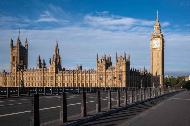 Iconic view of Big Ben and the Palace of Westminster in London, UK, under a blue sky.
