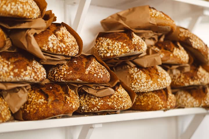 Freshly baked sourdough loaves stacked on shelves in a Dunkeld bakery.