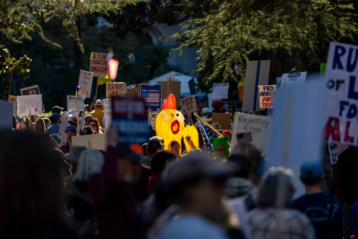 A vibrant protest scene capturing various signs and symbols in downtown Sacramento.