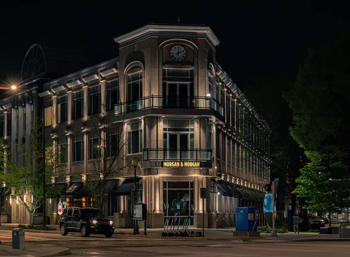 A beautifully illuminated historic building at night, featuring a prominent clock tower.