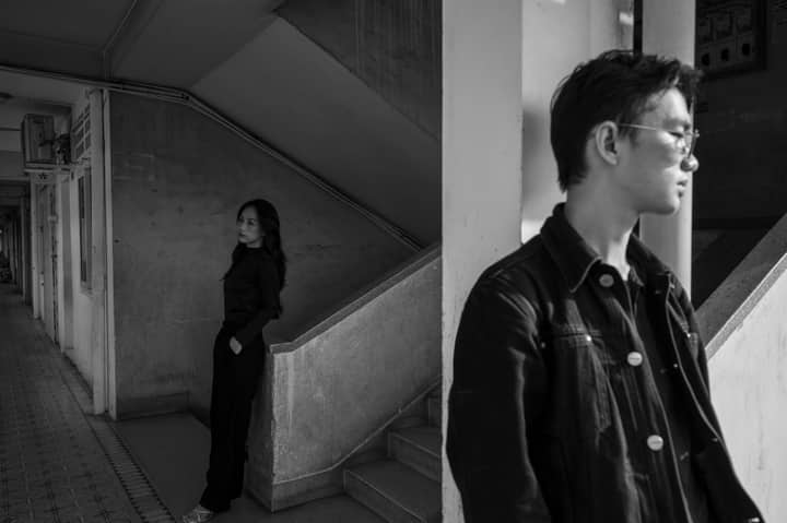 Monochrome portrait of two adults in an urban setting, creating a dramatic mood.