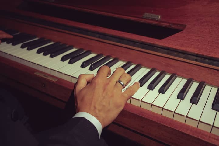 A musician's hands skillfully playing a wooden piano keyboard. Classical music performance.