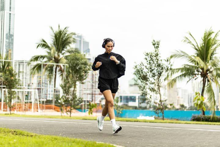 A woman enjoying a morning run in a vibrant park in Panama City, Panama.