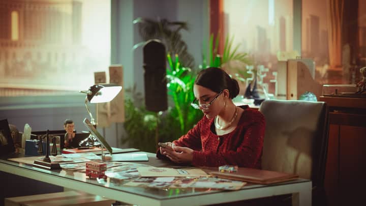 Woman using smartphone in a modern office with cityscape background, Baghdad, Iraq.