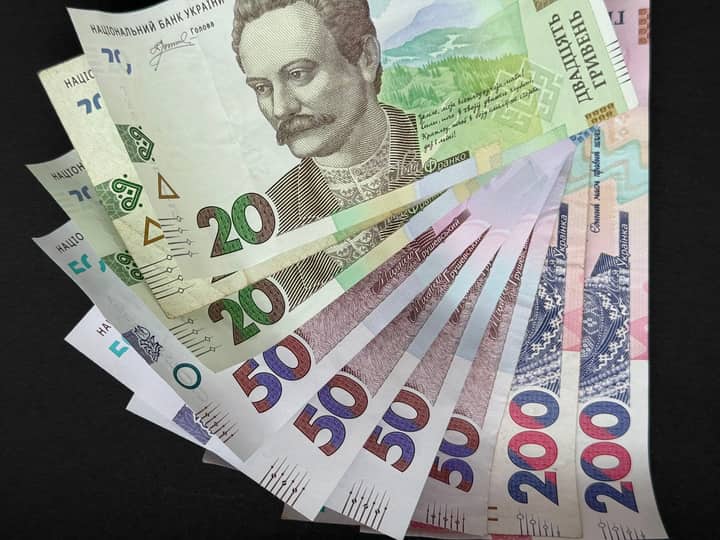 Fanned out Ukrainian Hryvnia banknotes featuring various denominations and vivid colors.