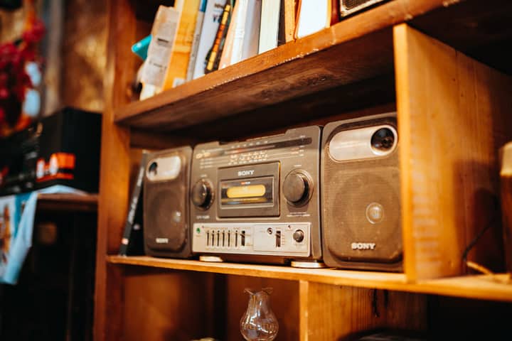 Close-up of a vintage Sony radio on a wooden bookshelf in a cozy setting.