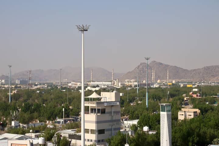 Aerial cityscape view featuring a mosque and mountains in Saudi Arabia.
