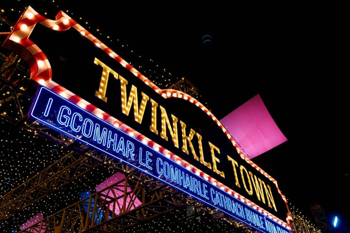 Festive illuminated sign displaying 'Twinkle Town' at night, capturing a vibrant festive atmosphere.