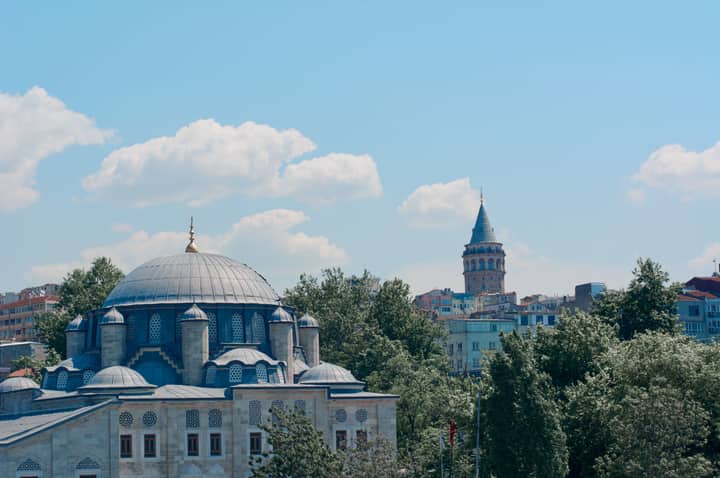 A stunning view of a mosque and the historic Galata Tower in Istanbul, Türkiye.