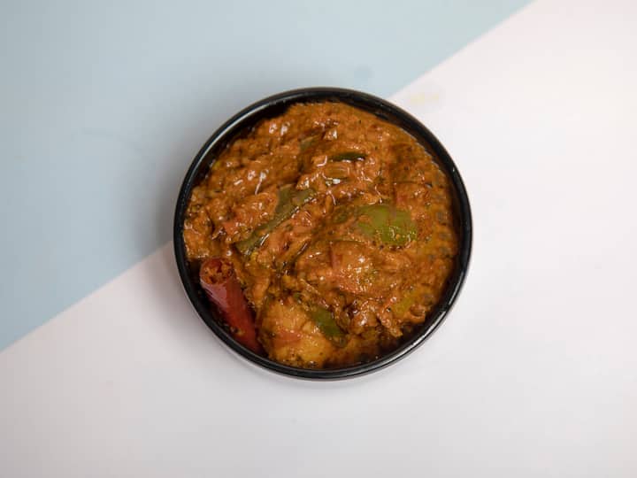 Top-down view of flavorful Indian vegetable curry in a black bowl, perfect for food presentations.