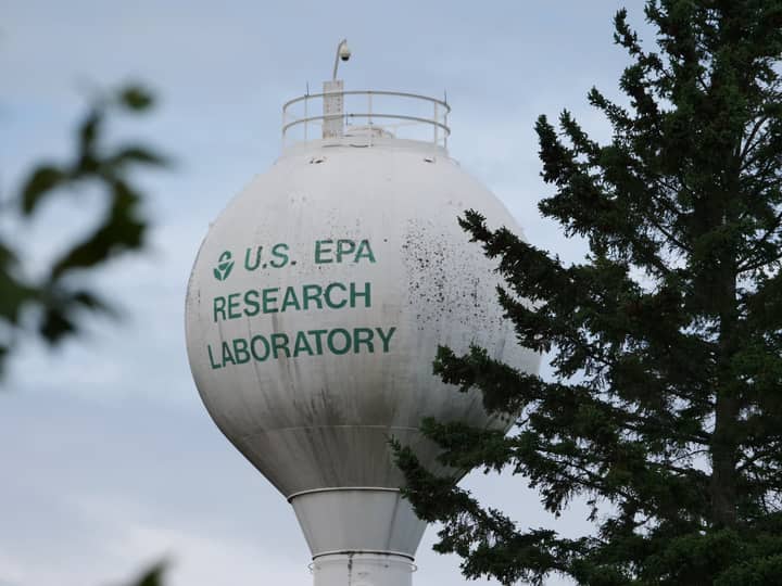 U.S. EPA Research Laboratory water tower with trees in view.