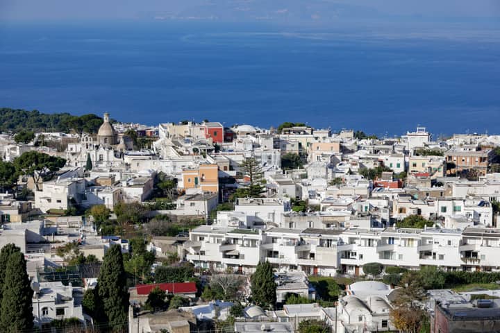 Charming aerial view of Capri's whitewashed buildings and Mediterranean Sea.