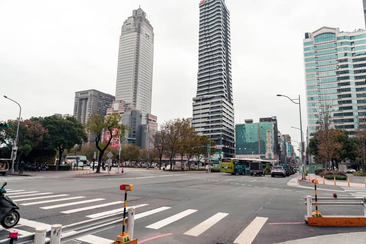 A bustling intersection in Taipei, Taiwan, showcasing modern skyscrapers and city life.