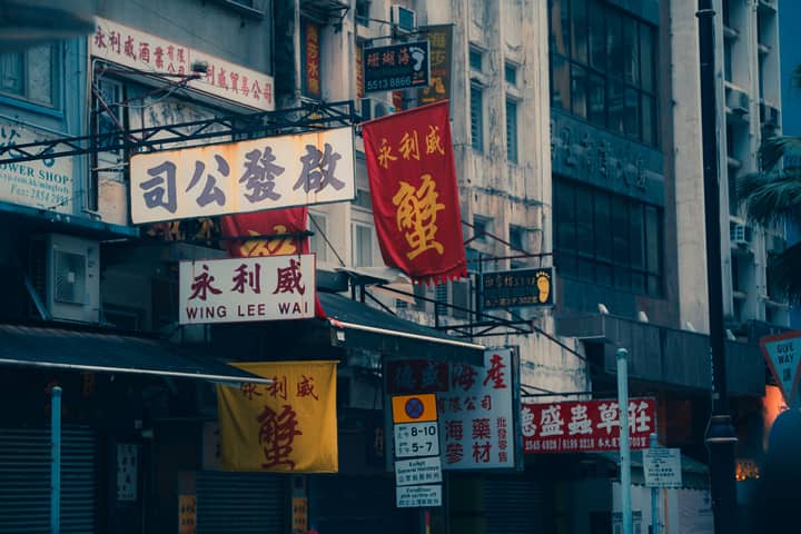 Colorful street signs on a bustling Hong Kong street showcasing local business culture.