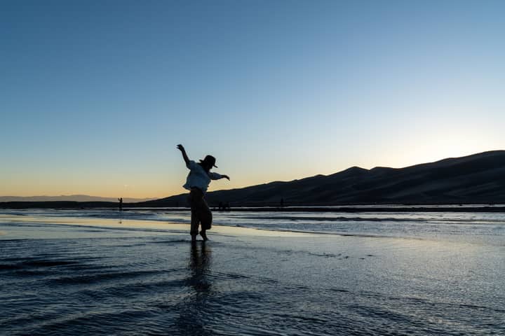 A cowboy silhouetted against the dusk at the stunning Colorado sand dunes, capturing an adventurous spirit.