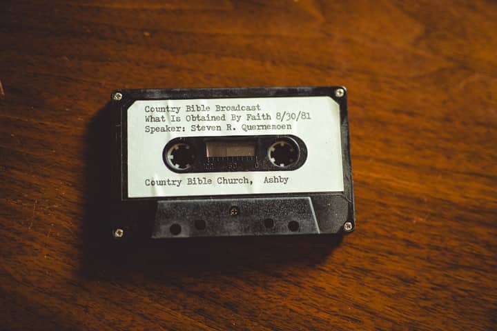 Close-up of a vintage cassette tape labeled with a 1981 Bible broadcast from Ashby, Minnesota.