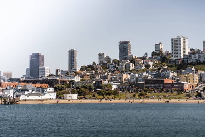 A scenic view of San Francisco's coastal skyline with beachfront and urban landscape.