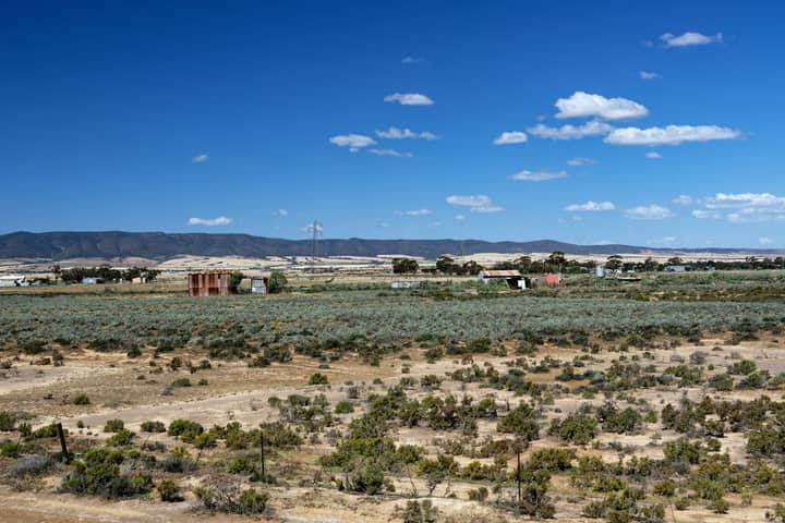 Expansive rural landscape with blue sky and distant hills in South Australia.
