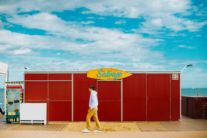 Vibrant red beach hut with a blue sky in Barcelona, Spain.