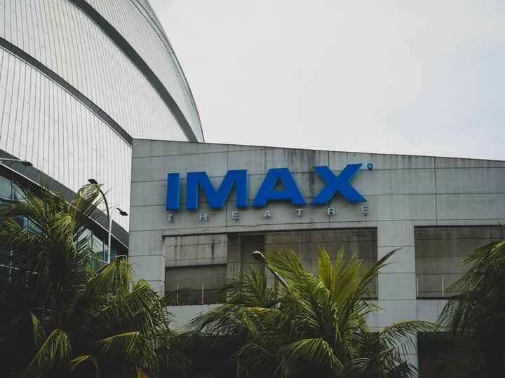 Exterior view of IMAX Theatre in Pasay City, Philippines with palm trees.