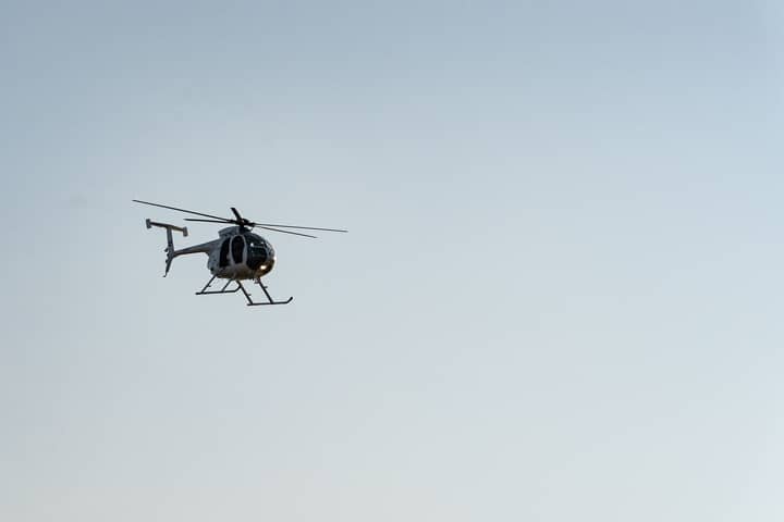 A helicopter flying in the clear blue sky above El Salvador, showcasing aviation in a serene setting.