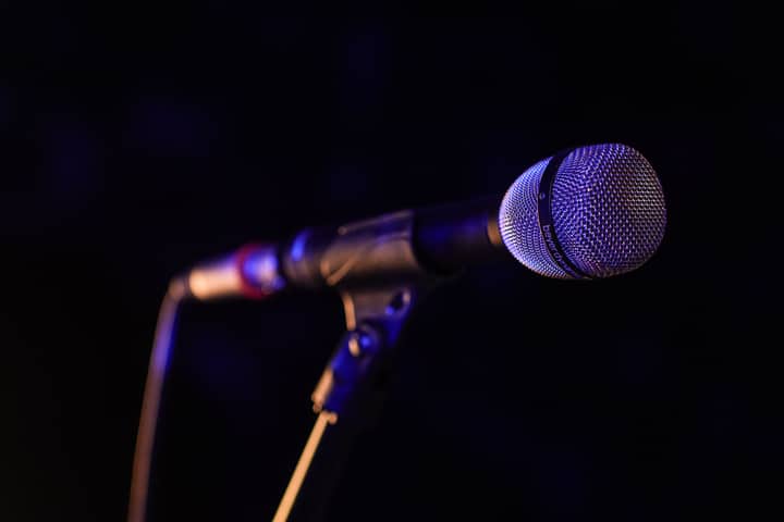 Close-up of a microphone set up on stage, highlighting concert ambiance.