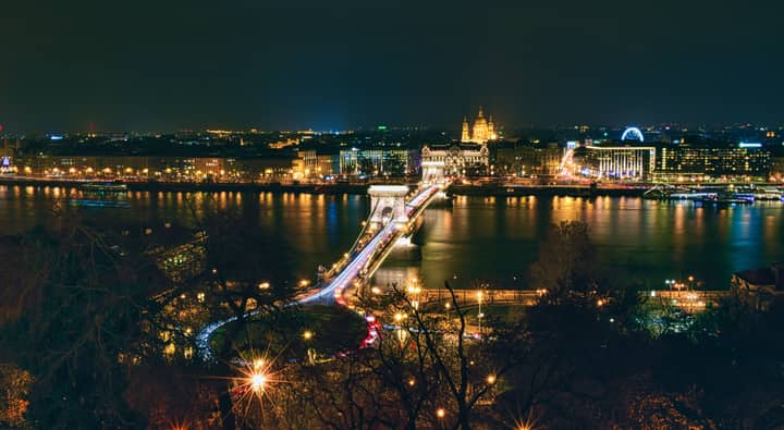 Scenic night view of Budapest's Chain Bridge with city lights reflecting on the Danube River.