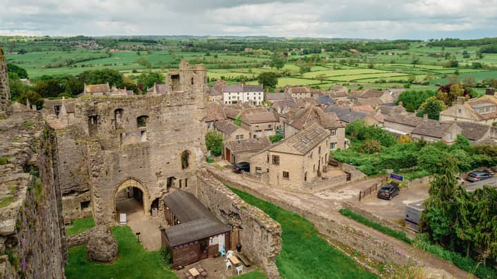 A scenic view of Middleham Castle ruins and surrounding countryside in Middleham, England.