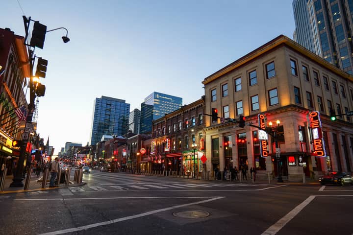 Lively street view of Nashville's Broadway, showcasing bright lights and bustling nightlife.