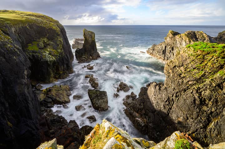Stunning view of Scotland's Outer Hebrides cliffs and sea, showcasing rugged beauty.