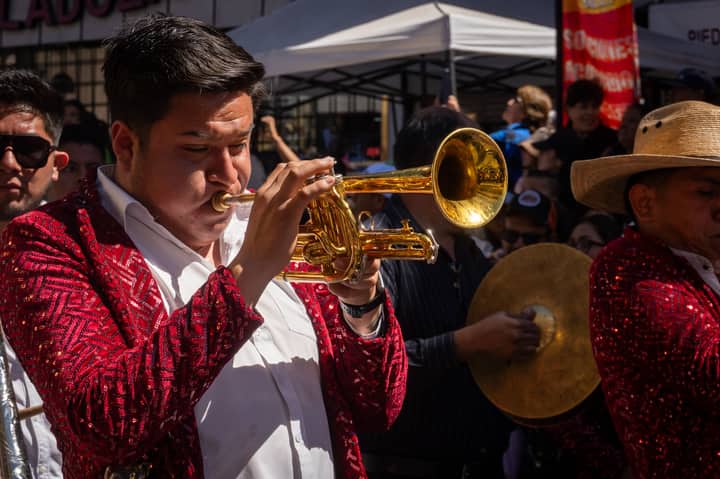 A vibrant brass band plays during a lively street carnival in Hidalgo, Mexico.