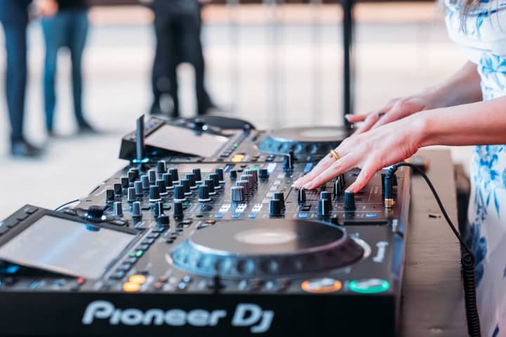 Female DJ performing with professional equipment at a Sydney event, showcasing talent and technology.