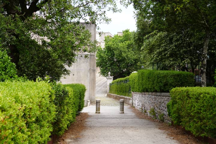 Peaceful pedestrian pathway surrounded by lush greenery in Erice, Sicily, Italy.
