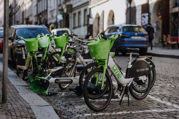 Lime electric bikes lined up on a cobblestone street in Prague, Czech Republic.