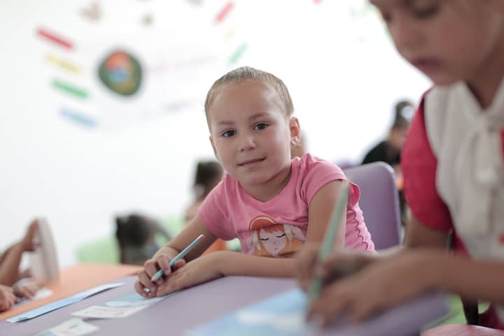 Young children actively participating in creative activities in a classroom setting, fostering learning and development.