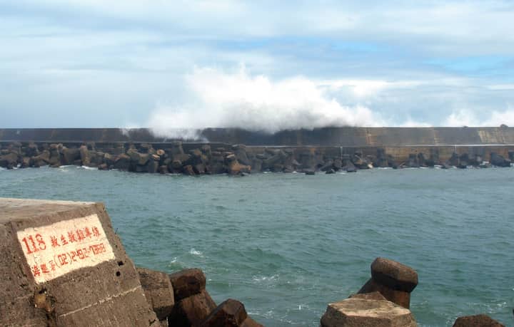 Powerful waves crash against the harbor wall in Wanli District, New Taipei City.